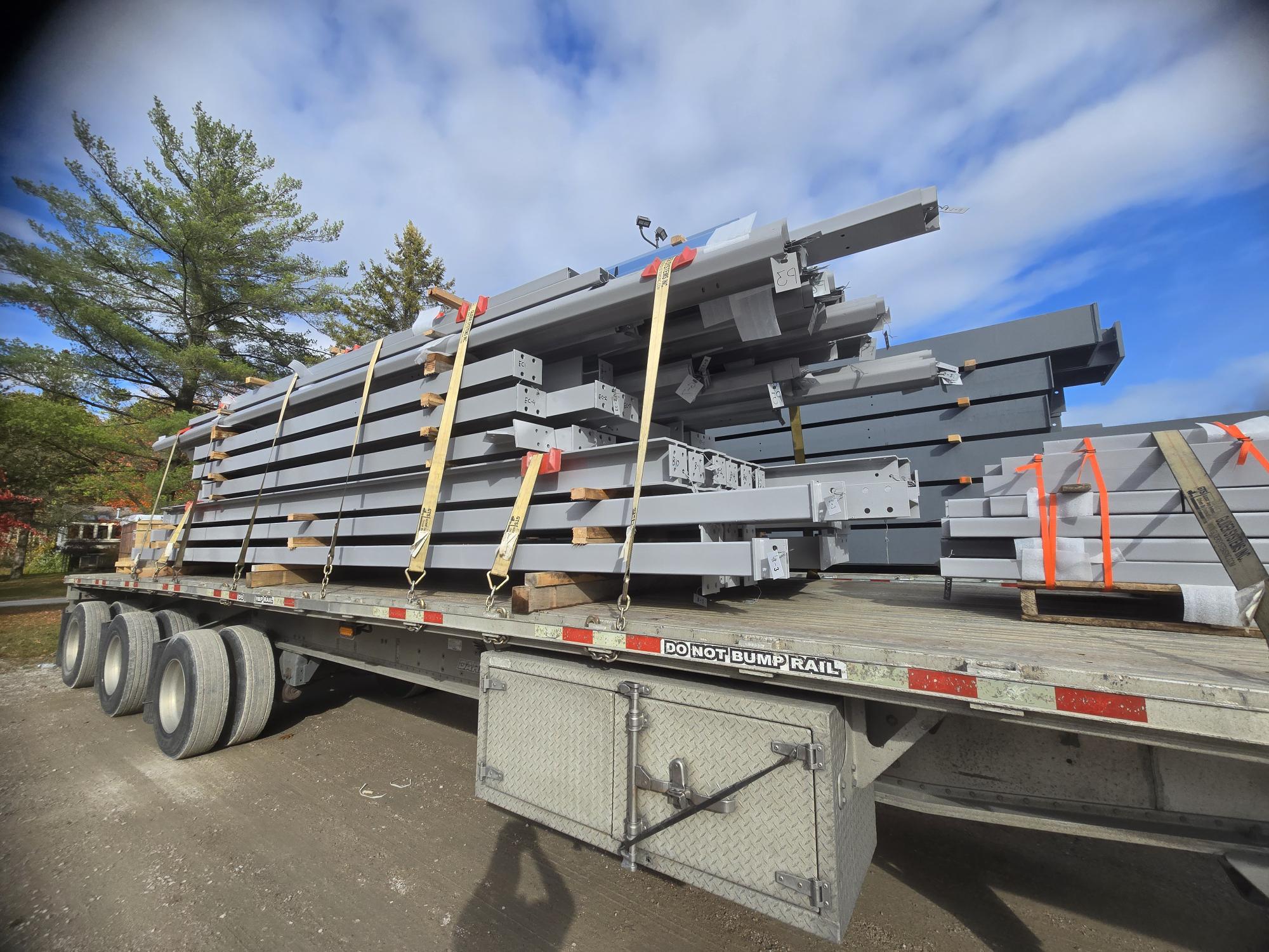 Steel building components on a flatbed truck for delivery within Canada